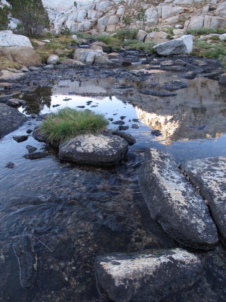 Reflection of mountain peak in a quiet stream